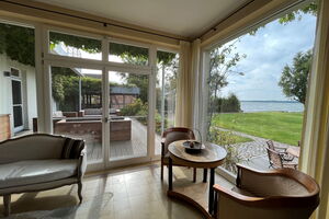 Ferienhaus Peeneblick - Panoramafenster mit Blick auf das Grundstück am Wasser